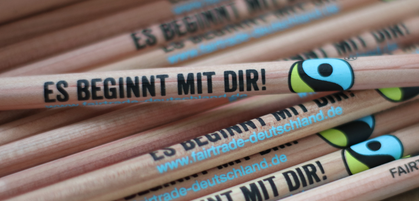 Nahaufnahme Bleistift mit Logo Fairtrade und Schriftzug 'Es beginnt mit dir